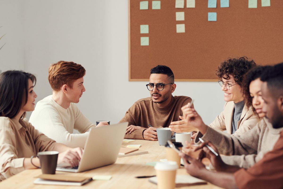 Equipo intercambiando ideas alrededor de una mesa de trabajo